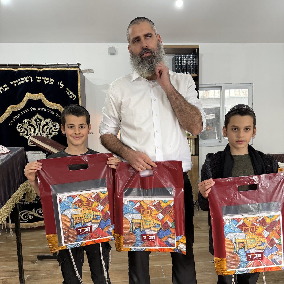 הרב עם ילדים ושקיות מצה שמורה לפסח